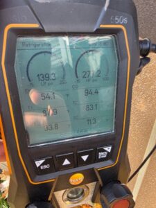 Close-up of a digital refrigeration gauge displaying pressure readings of 139.3 and 277.2 psi, along with temperature and CO values on its screen.