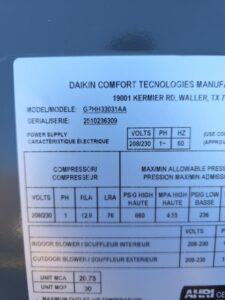 Close-up of a Daikin Comfort Technologies equipment label displaying model number GPHH33031AA, serial number 2510236039, and electrical specifications.